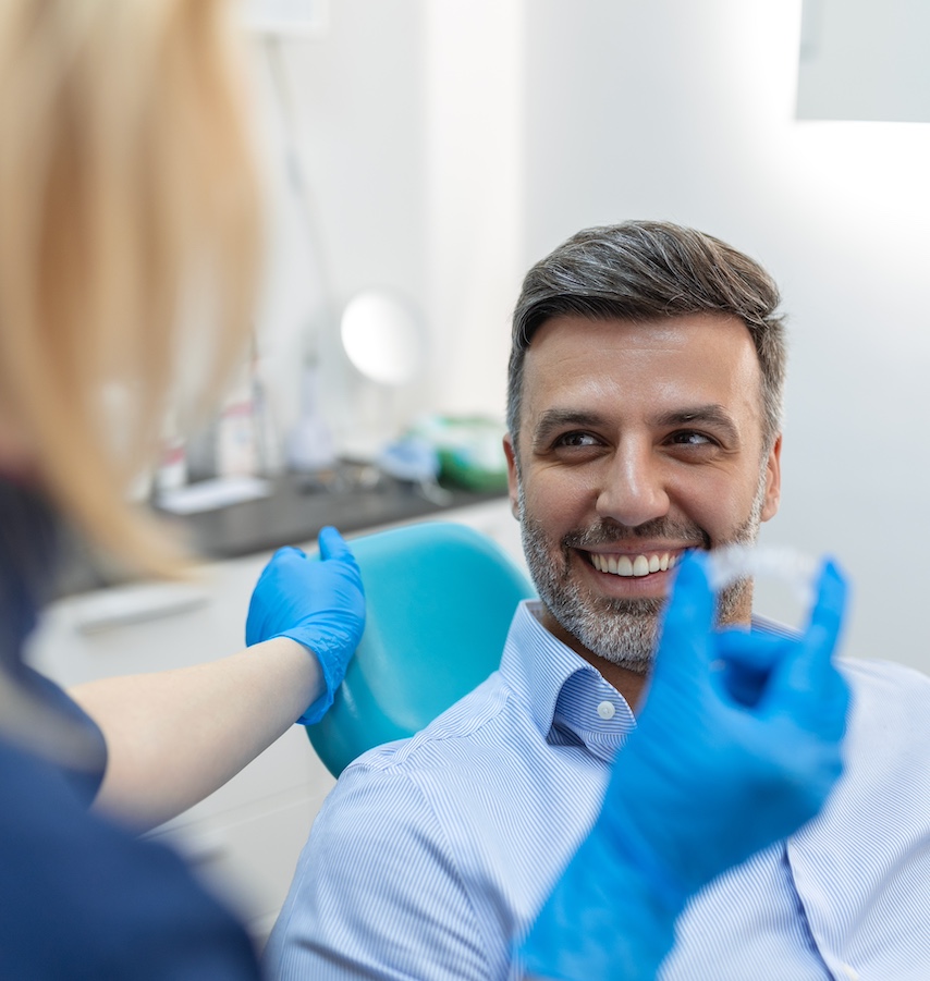 A young female dentist showing invisalign to patient in dental clinic, teeth check-up and Healthy teeth concept